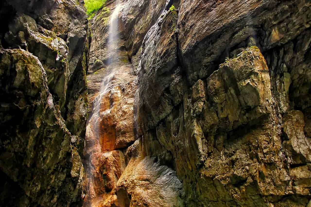 Felsformationen in der Partnachklamm bei Garmisch-Partenkirchen. Wasser spritzt von oben über die Felsen.