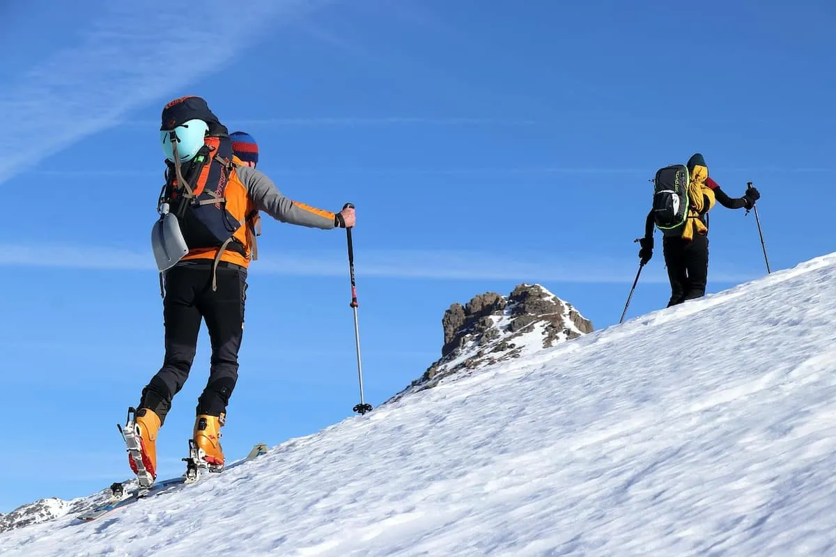 zwei skitourengeher beim aufstieg in den bergen in oberbayern